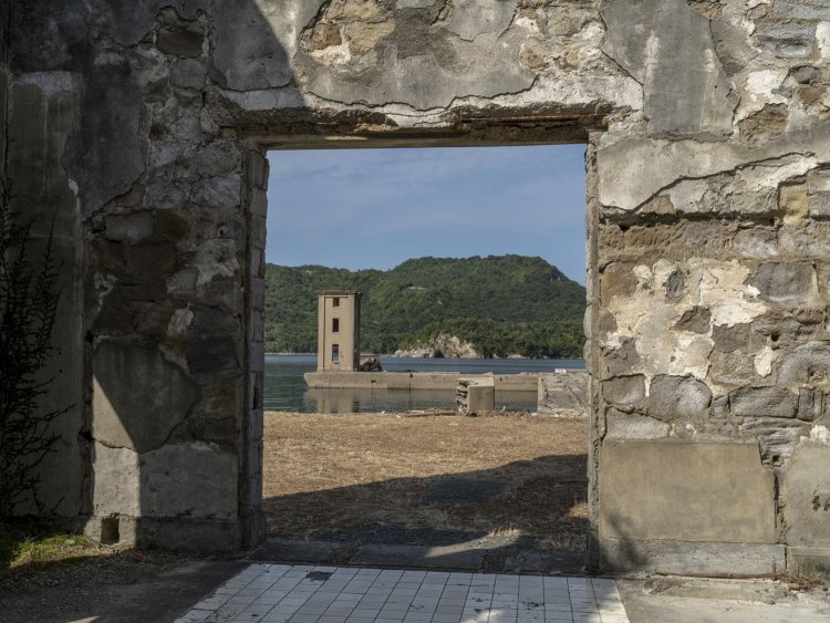 空気圧縮ポンプ所の入口から射場の塔屋を望む。扉の枠が額縁となって一葉の絵にすら見えてしまう。