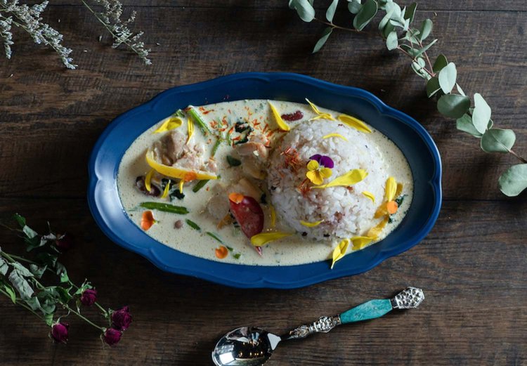 花々に彩られたイエローカレー。ココナッツミルクとの甘みとスパイシーさを感じる本格的な味だ。