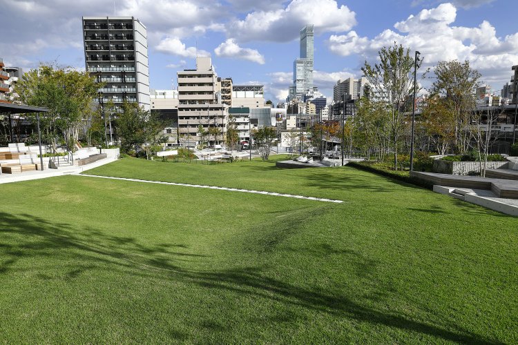 遠くにあべのハルカスを望む絶景。いたるところにベンチやクッションなど休憩スペースが。