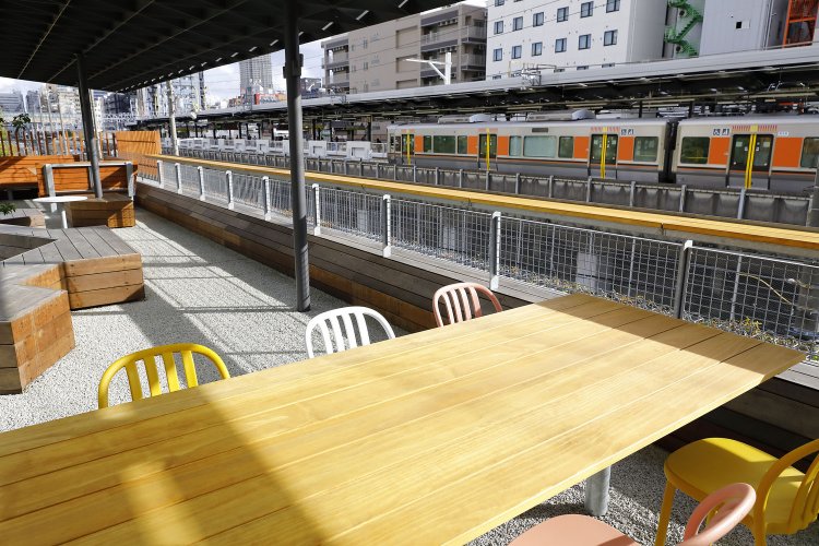 みやぐりんの東屋やカフェは、駅のホームと同じ高さに設計。JR新今宮駅で電車を待つ人と目が合う。