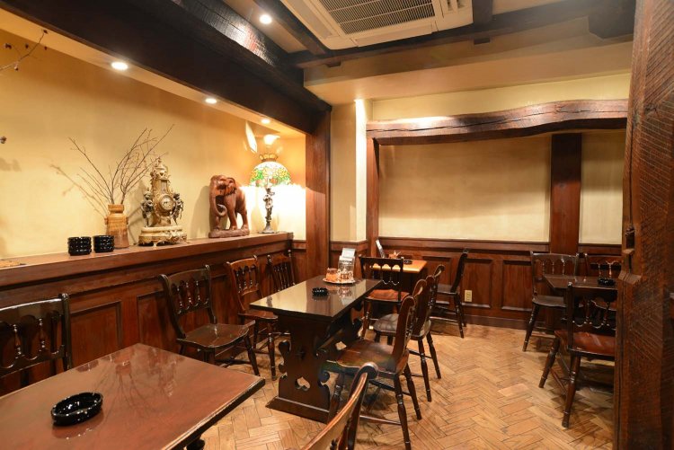 電子たばこが吸える喫煙ルーム。台座のある時計やシェードランプなど調度品が雰囲気を盛り上げる。