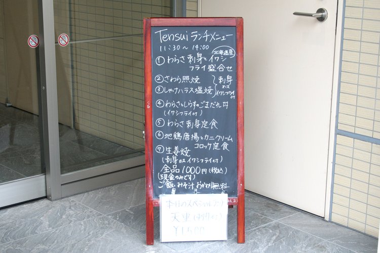 その日のランチメニューはビルの入り口に出されたボードで確認できる。地鶏唐揚、生姜焼きなど、お肉メニューも用意されている。