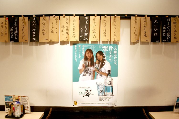 小池さんの2人の娘さんはソウル・ヴォーカル・デュオ“WAY WAVE”として活動中。お店の壁にはお2人がモデルのお酒のポスターが。左が杏奈さん、右が優菜さん。