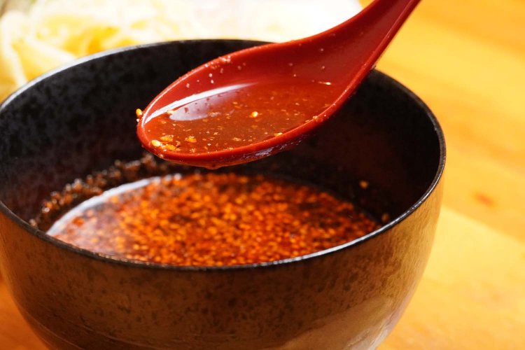 赤いレンゲと同化するほど、真っ赤なつけ汁。