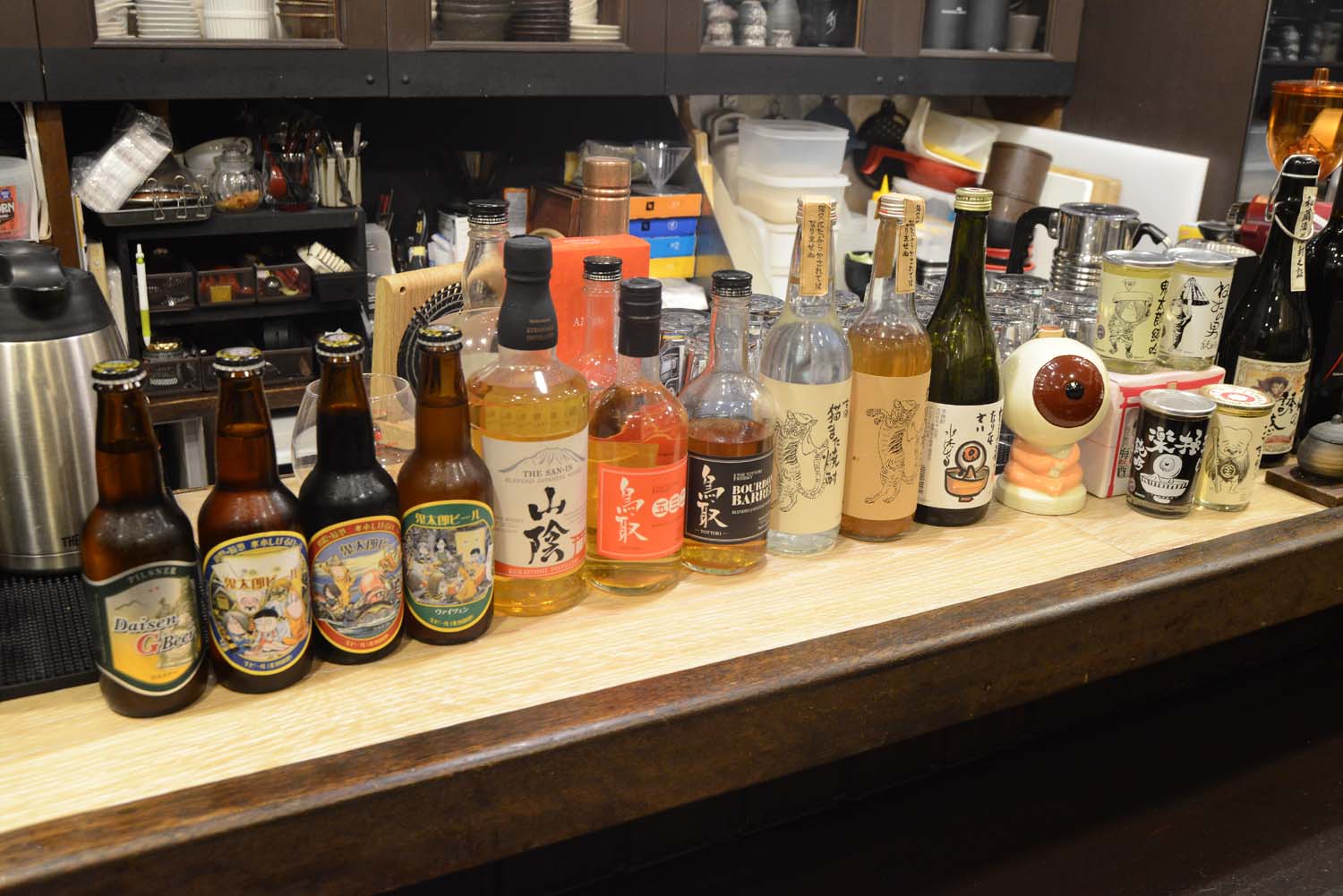 カウンターには各種酒のボトルが並び、『ゲゲゲの鬼太郎』ラベルのお酒もある。