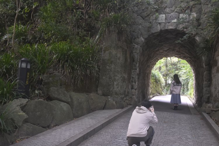 正面ゲートを抜けてすぐに出てくるトンネル。その左手外灯が歌碑。