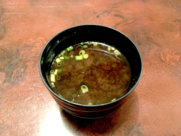 赤だしの味噌汁。具はわかめ。ランチタイムでは、ご飯と味噌汁はおかわり自由だ。
