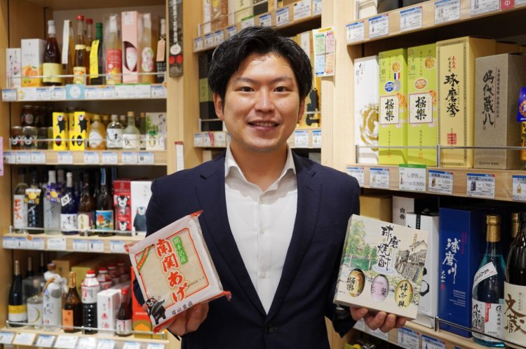 『熊本銀座館』の濵田さん。南関あげと球磨焼酎を手にした、爽やかな笑顔である。