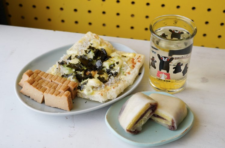 盛り付けると、淡い色合いの素朴なおつまみセットになった。通潤橋をくまモンが駆けていくカップ酒のデザインが可愛い。