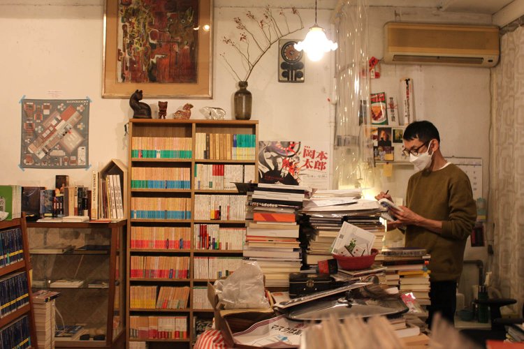 買取本を精査する店主の天野さん。