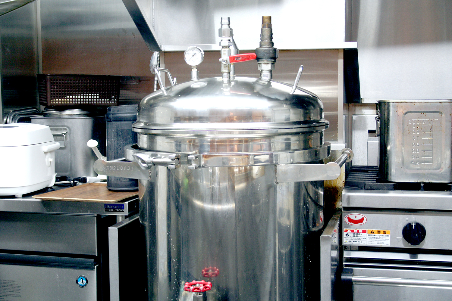 厨房にドーンと鎮座する巨大な圧力寸胴。約1.6気圧、136度で炊き上げる。