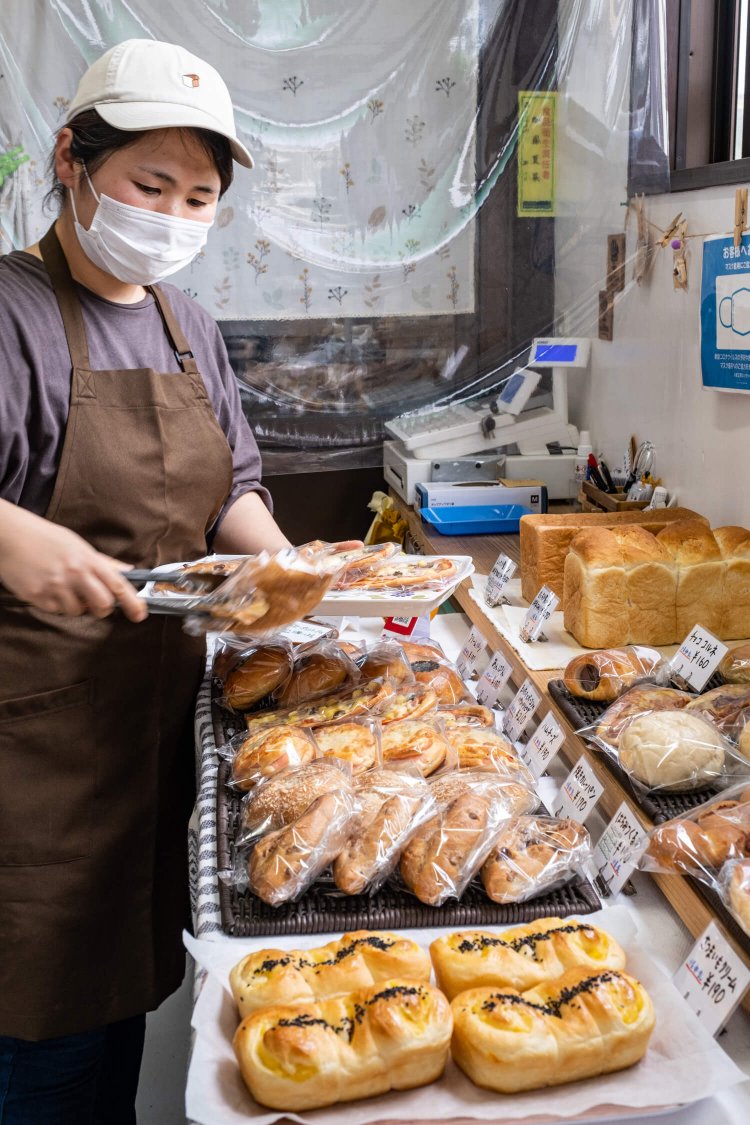 焼きたてのパンを並べる“なっちゃん”こと店主の加藤夏美さん。