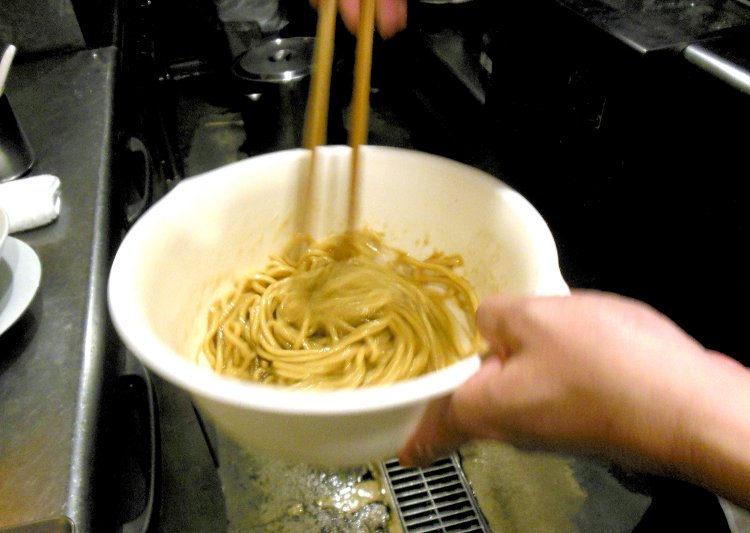 茹で上がった麺にオリーブオイルをたっぷりからめて、手早く特製しょう油ダレと和える。