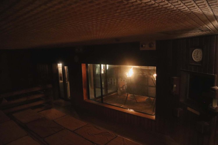 薄暗い高温サウナの窓から浮かび上がるようなかがり火が幻想的だ。