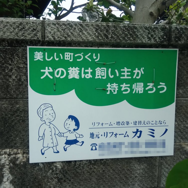 企業広告と一体化した犬くそ看板。