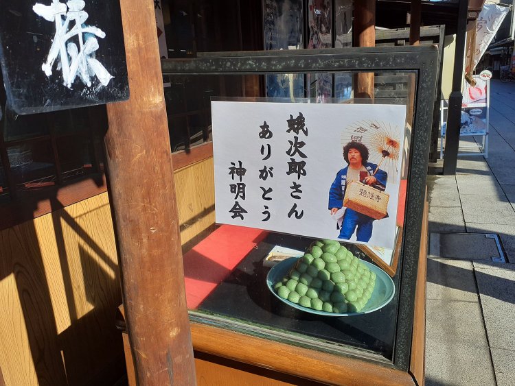 帝釈天参道の店々に掲げられた佐藤蛾次郎さん哀悼のポスター。写真は映画からの引用ではなく数年前の「寅さんサミット」時のものだとか。「ありがとう」の言葉に蛾次郎さんの人柄が偲ばれる。