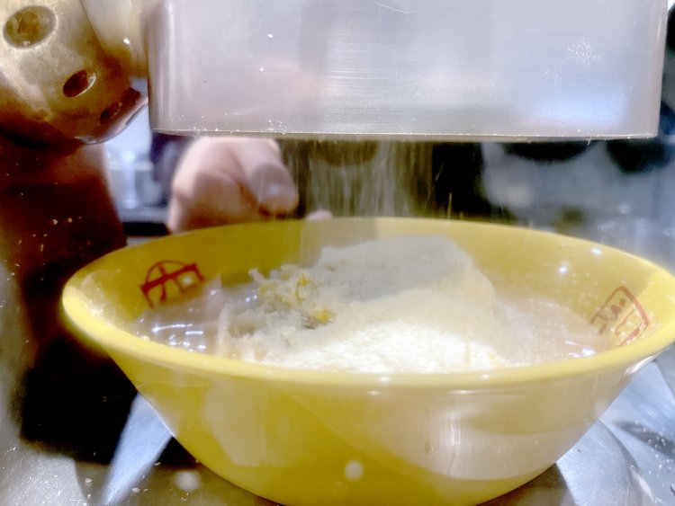 チーズグレーダーで60gのチーズをすり下ろしてこんもりふりかける。渡辺さんは「おそらく全国で初めてグレーダーを導入したラーメン店じゃないでしょうか」と笑う。