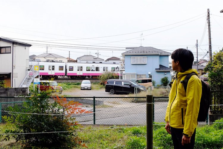 「ふれあいの森」の木立の間に新京成線の電車が見える
