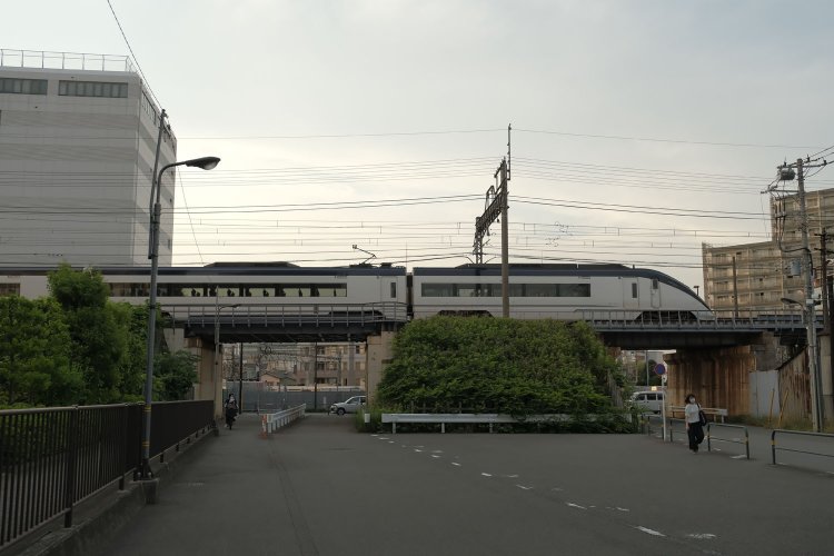 京成線高架橋は短い鉄桁の橋で道路と交差する。写真は隅田川を背にした方向から撮影し、奥が東武鉄道の位置関係である。左側の道路が東武千住線という貨物線であった。