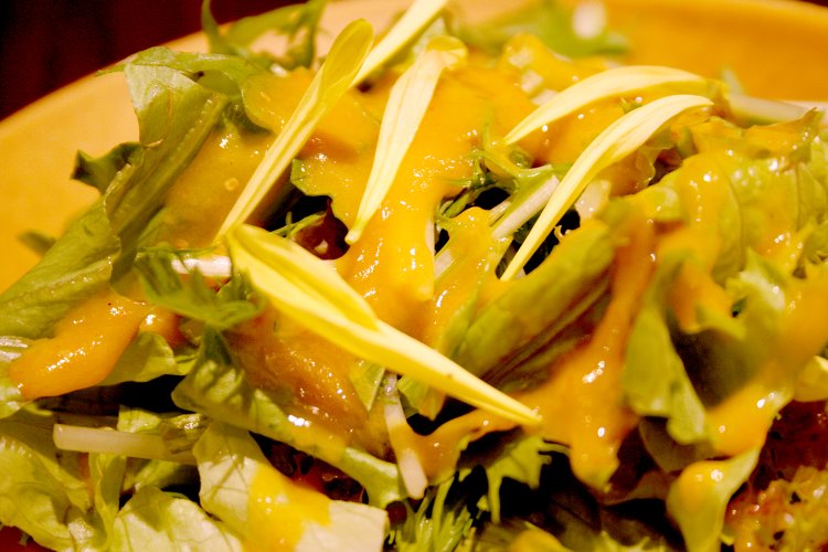 菊の花びらが印象的なサラダ。ドレッシングは日替わりで、この日はクコの実のドレッシング。