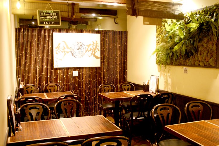 1階のテーブル席。壁には黒竹があしらわれ、和モダンで落ち着いた雰囲気。