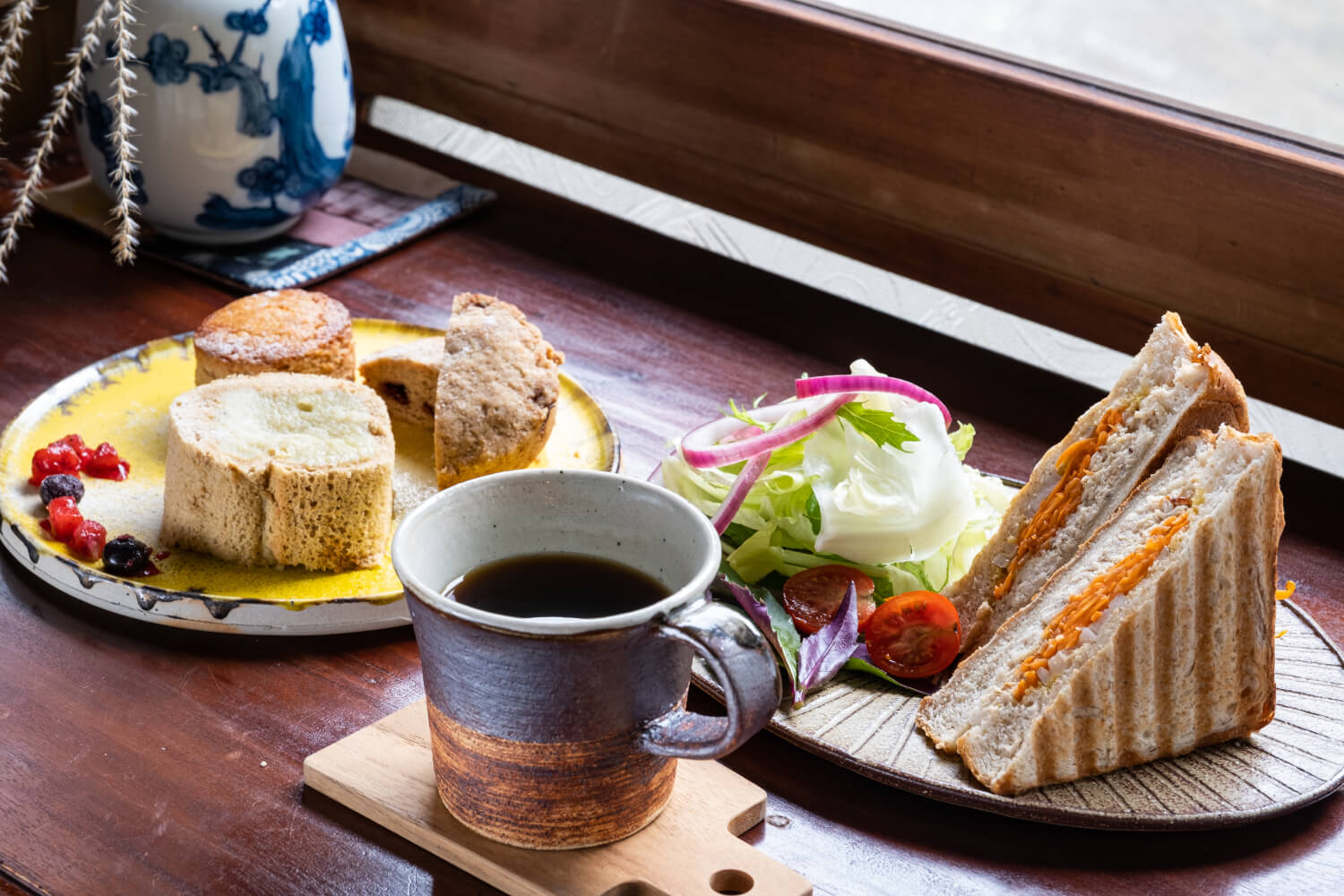 自家製パニーニの日替わり年茶屋セット1200円（コーヒー付き／右）。時価で提供する虹色おやつはスコーンやタルトなどどれもおいしそう。