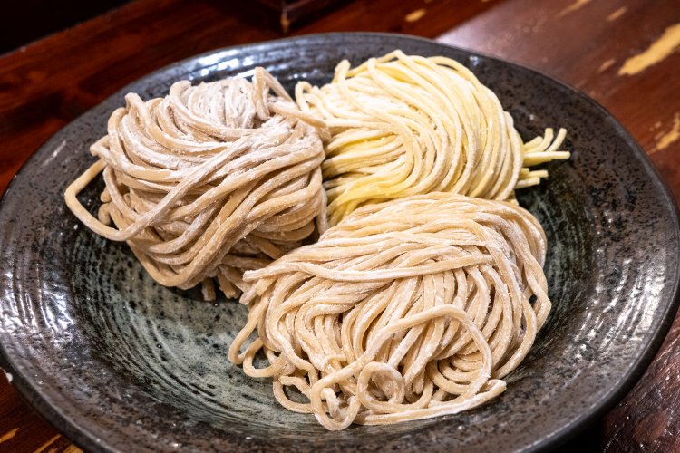 現在、麺は3種類。太麺と極太麺は全粒粉入り。手前の太麺はつけ麺、右後ろの中太は本家 田ぶし らーめんなどに使われている。極太麺は、20周年記念商品 ド煮干しつけ麵用だ。