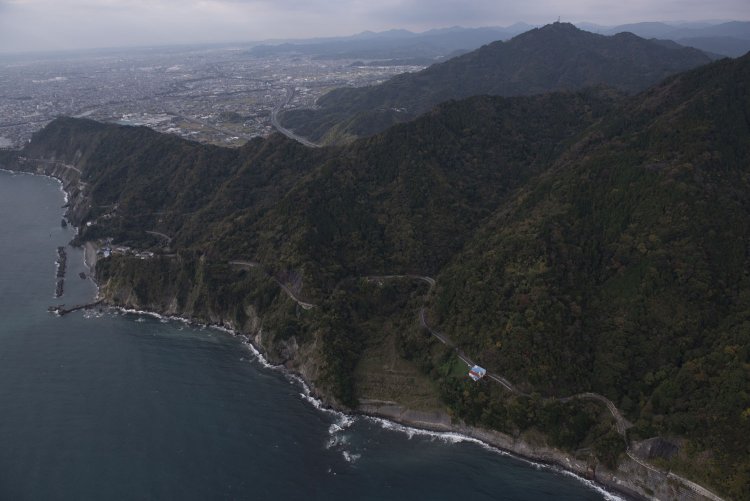 北東方向から見た大崩海岸。山塊が海岸線ギリギリに迫り出している。写真右下付近に石部トンネル旧西側坑門がある。東海道本線は崖にへばりつくように線路があった。2016/11/30撮影。