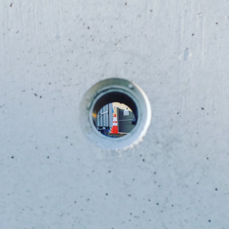 穴越しに見える、赤いパイロン。