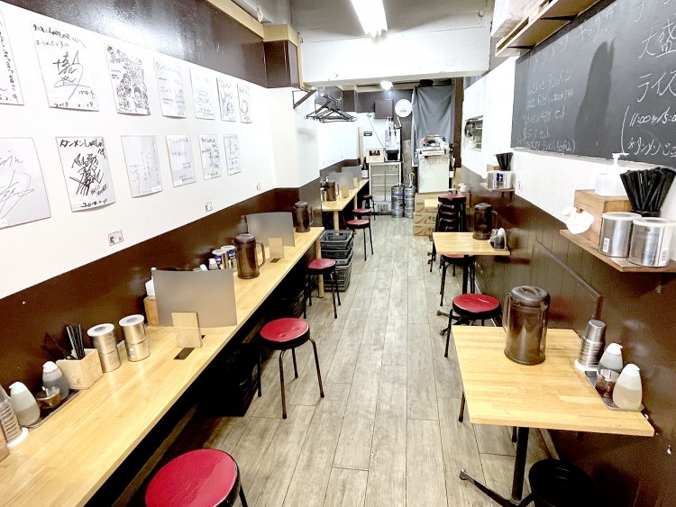 細長い店内にカウンター席とテーブル席が並ぶ。