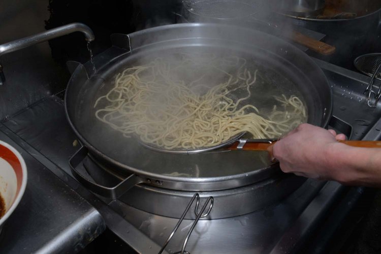 麺はテボ（小さなザル）で茹でるのではなく、お湯の中を泳ぐようにして茹でられる。