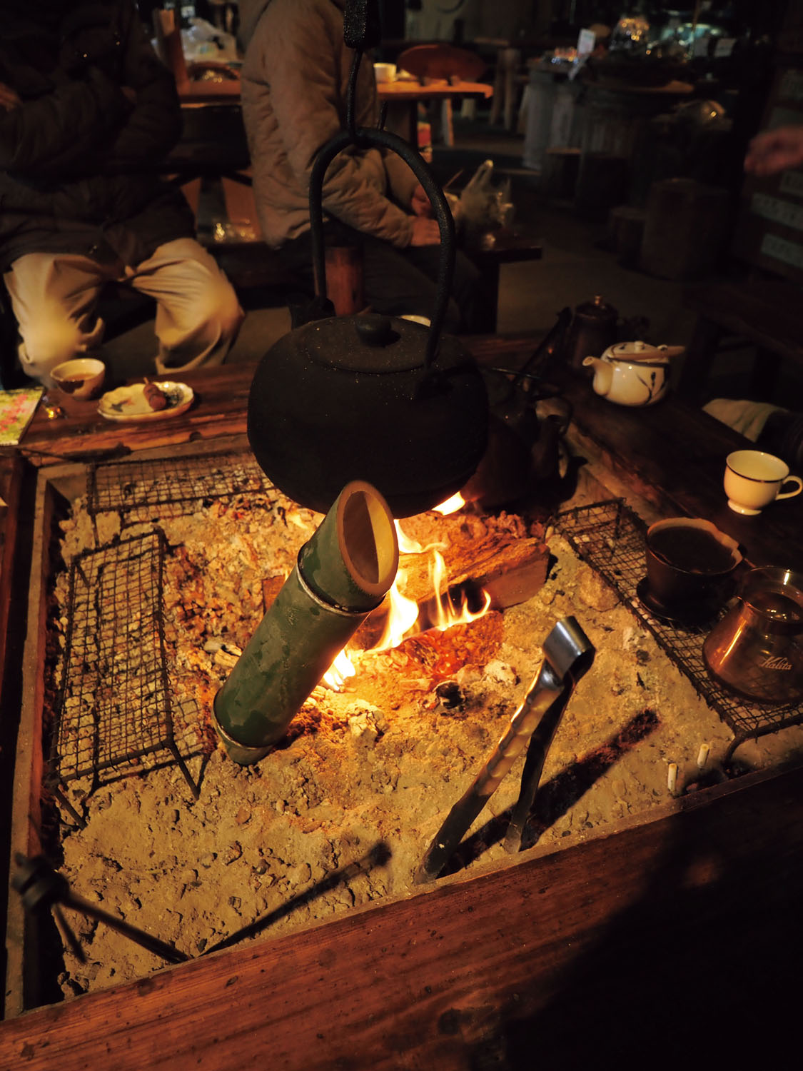 囲炉裏では自分で団子を焼いて食べられる。火のそばにある竹筒はカッポ酒で、日本酒を入れてお燗して飲む。