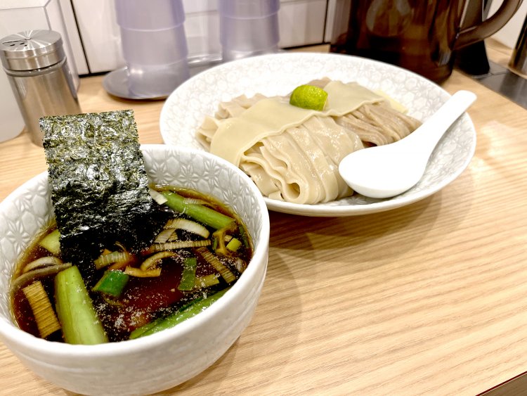 和風の紋様が上品な器に盛られて着丼した合盛りつけ麺。つけ汁の中にはチャーシュー、ネギ、江戸菜、海苔が入っている。