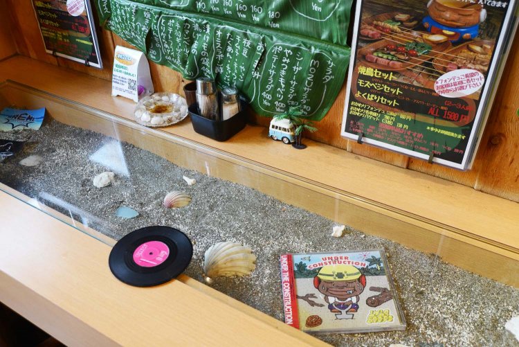 砂や貝殻をディスプレーしたカウンター席。小さいレコード盤はコースター。
