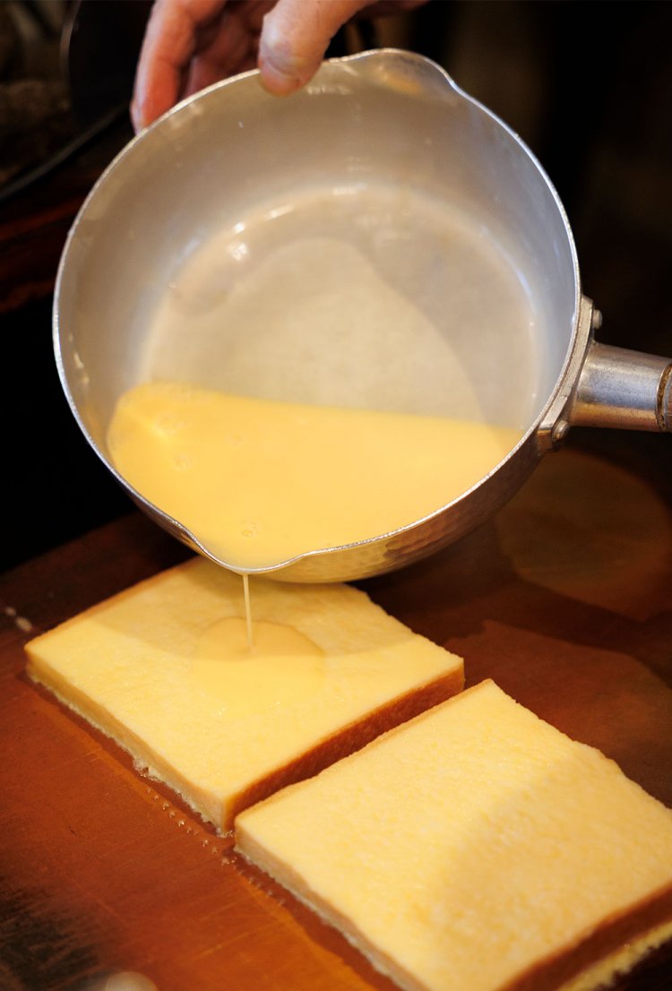 卵液を少しかけ、両面にバターを塗りながら銅板でじっくり焼く。２枚重ね。