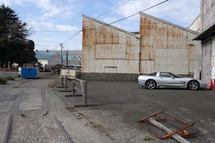 埋もれかける線路とE倉庫。ノコギリ屋根の建物も随分と減ったものだ。この場所はストリートビューで見る限り、現在は緑色のフェンスで囲まれているが、線路の痕跡はうっすらと残っているようだ。