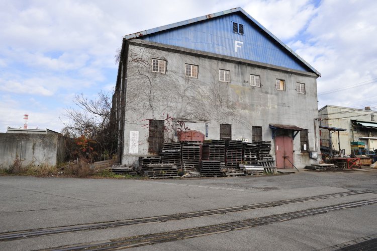 「F」倉庫の前を横切る専用線の線路。この倉庫は海軍時代から存在していた。ストリートビューでは蔦が絡まっているようだ……。