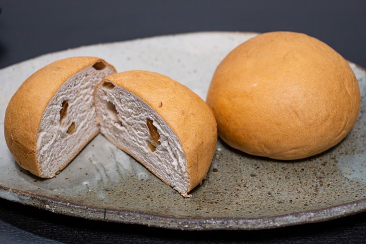 半円状の素朴なかたちに懐かしさを覚える元祖温泉パン（右／3個入り500円）とくるみ温泉パン（同600円）。