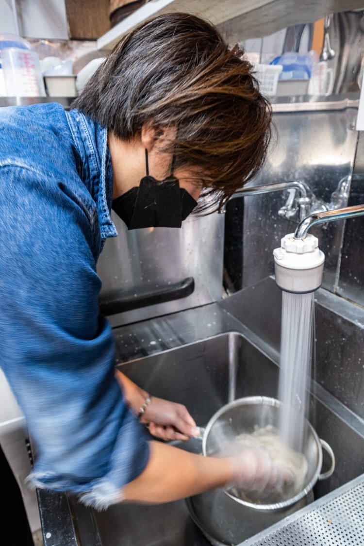 うどんを冷水にさらす店主の青木佑太さん。地産地消のメニュー考案にも余念がない。