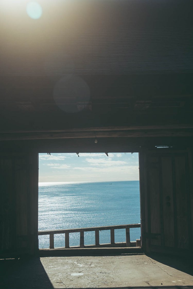 一ノ門をフレームのように見立て、煌めく駿河湾を収める。あえてフレアも写し込んでいる。撮影／ちょりんた（＠chorinta）