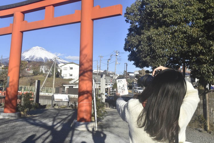 別の鳥居の前で、手に入れた御朱印を撮影中のちょりんたさん。