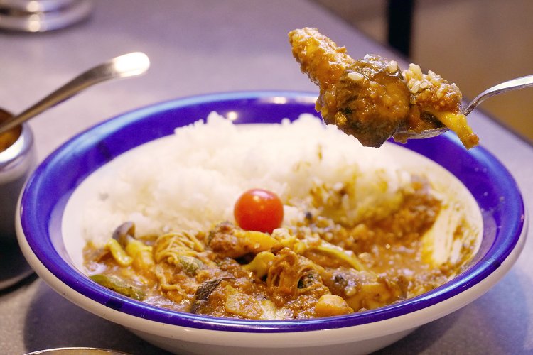 チキンのほかに、ブロッコリー、ナス、ピーマン、シメジ、エノキ、玉ねぎ、キャベツ、ひよこ豆、ミニトマトが入るが、旬に合わせて変化する。