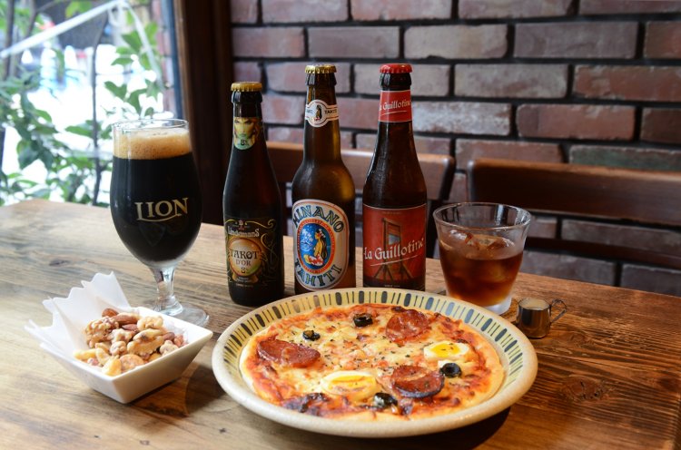 「ライオンスタウト」や「ギロチン」などビールはすべて瓶。ピザ900円やミックスナッツ450円。