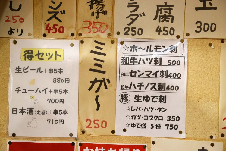 「ホ～ルモン刺」と書かれたメニュー表には豚内臓や牛内臓の料理がある。表示の金額は税別。ちなみに消費税は8％しか取らず、2％分は店で負担しているのだという。