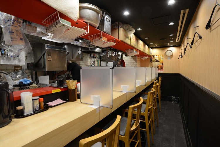 白木のカウンター席の上の棚には、仕入れた煮干しがずらりと並ぶ。