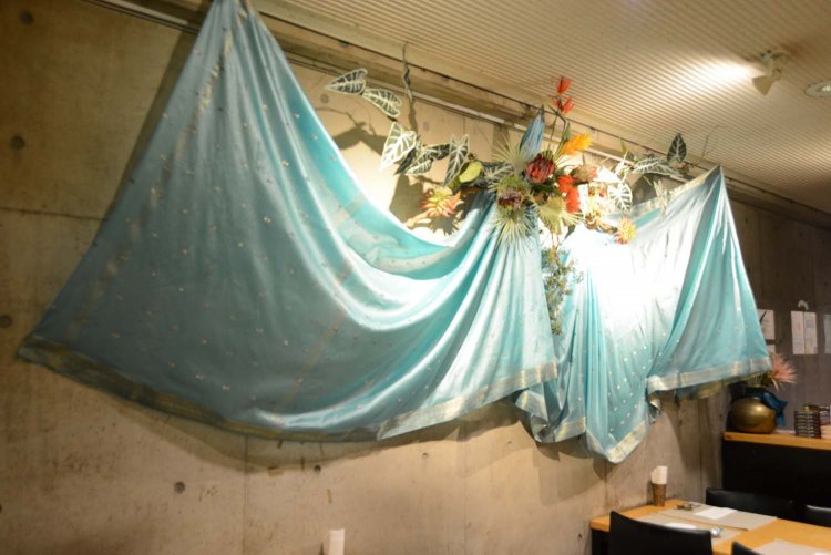 オーナーの古くからの知人であるアーティストが手がけたサリーの作品が店内を彩っている。