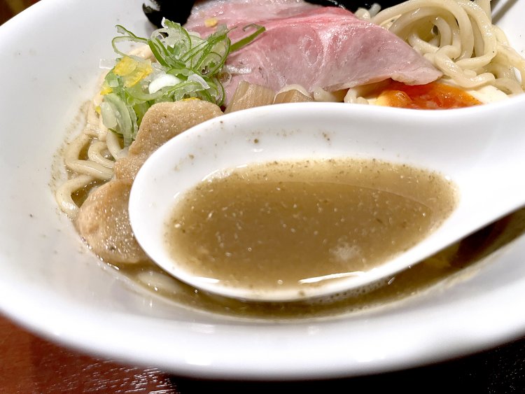 煮干しがたっぷり入ったスープ。麺は三河屋製麺の中太縮れ麺だ。