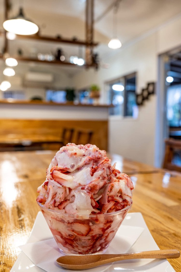 丸ごと凍らせた吉見産いちごを1パック以上スライスし、練乳をかけた こいいちご700円。店内はナチュラルテイストで開放的だ。