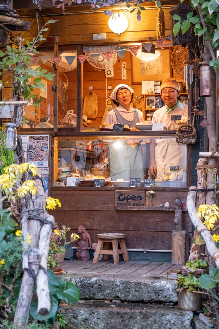 黙々とパンを焼く山口範友樹さん（右）と店頭に立つ美津江さん。
