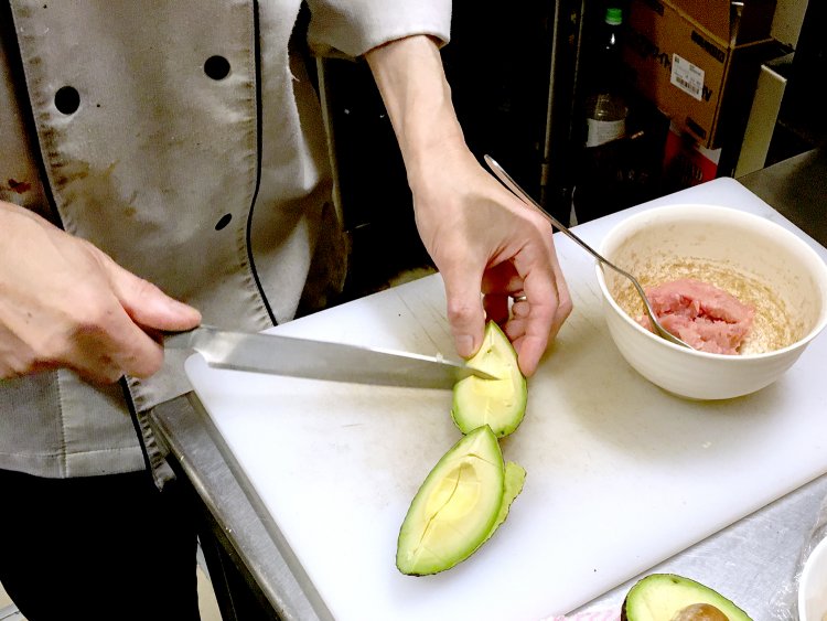アボカドを手際よく調理する店長の藤田さん。